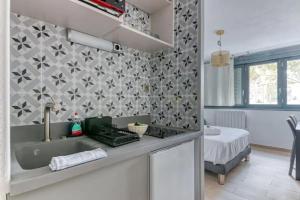eine Küche mit einem Waschbecken und ein Schlafzimmer in der Unterkunft Studio Cosy Coeur Part Dieu in Lyon