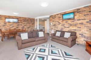 - un salon avec deux canapés et un mur en briques dans l'établissement Mainsail 3, à Port Macquarie