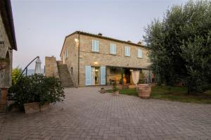 コルトーナにあるVilla Fattoria Le Giareの中庭が目の前にある大きなレンガ造りの家