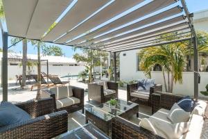 a patio with couches and chairs and a table at Coconut Walk To The BeachComfy Beds Firepit Pool in Fort Lauderdale