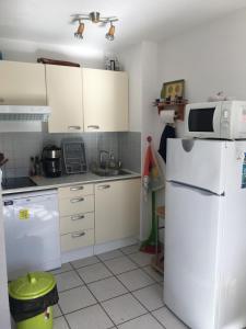 a kitchen with white appliances and a white refrigerator at Aloès in Cerbère