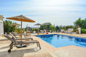 a pool with chairs and umbrellas next to at Villa Mama comfort et hospitalité in Essaouira