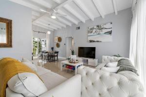sala de estar blanca con sofá blanco y TV en The Sandbar Walk To Beach Comfy Beds Firepit Pool, en Fort Lauderdale