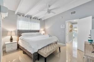 1 dormitorio blanco con 1 cama grande y techo blanco en The Sandbar Walk To Beach Comfy Beds Firepit Pool, en Fort Lauderdale