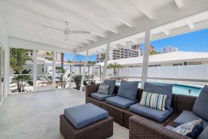 a patio with wicker furniture and a swimming pool at Seashell Walk To The Beach Comfy Beds Firepit Pool in Fort Lauderdale