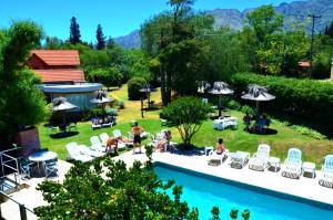 um grupo de pessoas sentadas em cadeiras à beira de uma piscina em Paradiso Hotel em Merlo