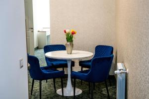a table with blue chairs and a vase of flowers on it at Agora Boutique Hotel in Sofia