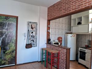 cocina con nevera blanca y pared de ladrillo en Prático e bem localizado Studio, na CB en Porto Alegre