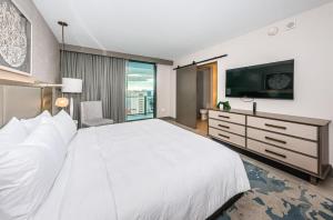 Un dormitorio con una gran cama blanca y un televisor de pantalla plana. en 1612 - Beachfront Condo, en Clearwater Beach 52 fotos más