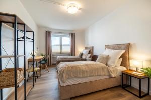 1 dormitorio con 1 cama y 1 silla en FeWo Vogel: City Wohntraum, en Bielefeld