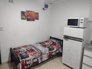 een kleine kamer met een koelkast en een magnetron bij Alojamiento en Chajarí in Chajarí