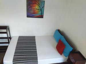 een bed in een kamer met een schilderij aan de muur bij TravelNest in Badulla