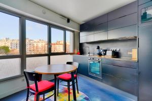 uma cozinha com mesa e cadeiras num quarto em Bright and spacious studio in Montreuil - Welkeys em Montreuil