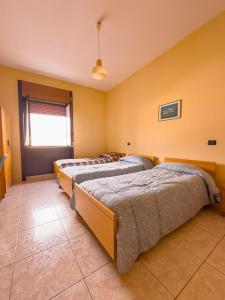 2 Betten in einem Zimmer mit gelben Wänden in der Unterkunft HOTEL 1+1 di C.Costabile & f.lli in Pontecagnano