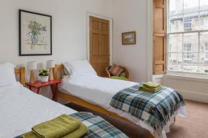 a bedroom with two beds and a window at Unique Edinburgh New Town Apartment near Princes Street in Edinburgh