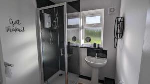 uma casa de banho com um chuveiro, um WC e um lavatório. em OPP Sidmouth - Cosy Coastal Chalet great views! BIG SAVINGS booking 7 days or more! - Dogs by Request Only em Sidmouth