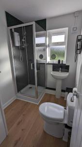 uma casa de banho com um chuveiro, um WC e um lavatório. em OPP Sidmouth - Cosy Coastal Chalet great views! BIG SAVINGS booking 7 days or more! - Dogs by Request Only em Sidmouth