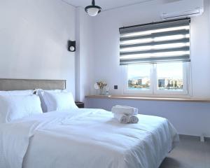 un letto bianco con un asciugamano sopra di OpenSea a Calcide