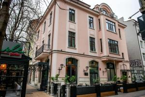 a pink building on the side of a street at Agora Boutique Hotel in Sofia