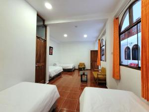 a hotel room with two beds and a window at Munay Ñusta in Cusco