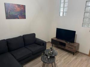 uma sala de estar com um sofá e uma televisão de ecrã plano em Nick's Place em Tessalônica
