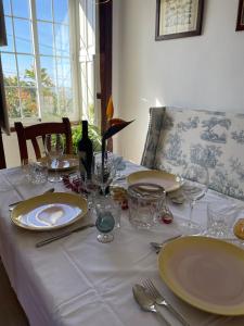 a table with plates and glasses on a white table cloth at Pino Redondo in Puntagorda