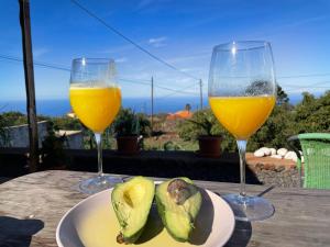 two wine glasses and a plate of food on a table at Pino Redondo in Puntagorda