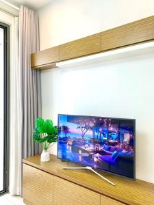 sala de estar con TV de pantalla plana grande en Golden Apartment en Ho Chi Minh