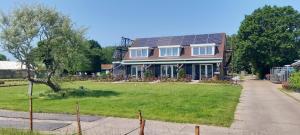 una casa con techo solar en un patio en Huis over de dijk, en De Kwakel