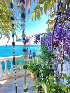Casa con maravillosas vistas al mar في أليكانتي: شرفة مع الزهور الأرجوانية والمحيط