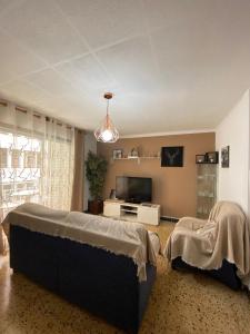 a living room with a bed and a tv at Apartamento Turístico en el centro in Tarragona