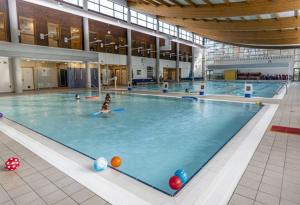 uma grande piscina interior com uma mulher em 3 bedrooms Sleeps 8 Self Catering House Near Norwich City Centre And UEA em Earlham