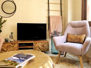 a living room with a chair and a television at Casa Secreta Vélez-Málaga centro in Vélez-Málaga