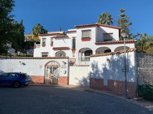 a white house with a gate and a fence at Villa La Casa de Pintor in Benalmádena