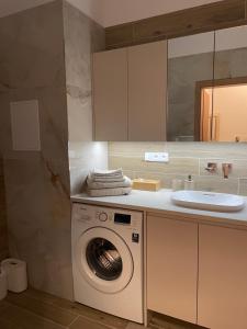 a bathroom with a washing machine and a sink at Castle View Apartment in Bratislava