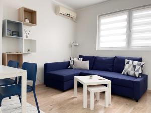 a living room with a blue couch and a table at Apartman Laguna in Donji Milanovac