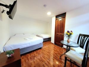 Habitación de hotel con cama, mesa y escritorio. en Munay Ñusta, en Cusco