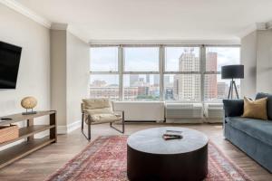 a living room with a couch and a table at CozySuites 800 Tower 1BR w sky pool, gym! 20 in Louisville
