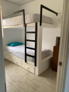 1 dormitorio con 2 literas y escalera en Loma house, en Caleta Grau
