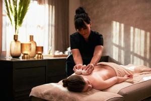 a woman is getting a massage on a bed at Das Traunsee - Das Hotel zum See 4 Stern Superior in Traunkirchen
