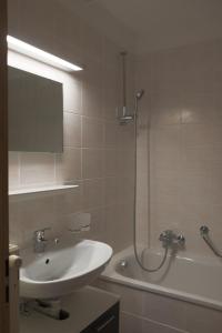 ein Badezimmer mit einem Waschbecken, einer Dusche und einer Badewanne in der Unterkunft Family friendly 2-Bedroom near Golf & Ski slopes in Lens