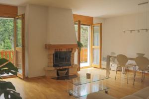 een woonkamer met een open haard en een tafel en stoelen bij Family friendly 2-Bedroom near Golf & Ski slopes in Lens