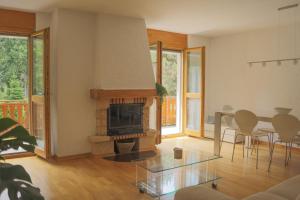 un soggiorno con camino, tavolo e sedie di Family friendly 2-Bedroom near Golf & Ski slopes a Lens