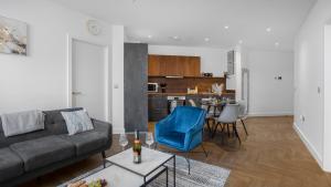 a living room with a couch and a blue chair at Priority Suite - Modern 2 Bedroom Apartment in Birmingham City Centre - Perfect for Family, Business and Leisure Stays by Estate Experts in Birmingham