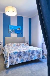 Pupatella Apartments في نابولي: غرفة نوم بسرير مع جدار ازرق