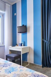 a bedroom with a desk and a tv on a blue wall at Pupatella Apartments in Naples
