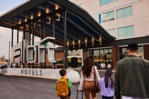 a group of people walking in front of a hotel at aloft Green Bay in Green Bay