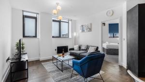 バーミンガムにあるPriority Suite - Modern 2 Bedroom Apartment in Birmingham City Centre - Perfect for Family, Business and Leisure Stays by Estate Expertsのリビングルーム(ソファ、テーブル付)
