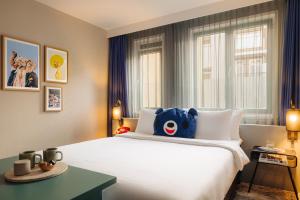 a bedroom with a large white bed with a teddy bear on it at The ED Amsterdam in Amsterdam