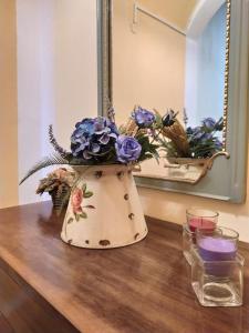 a vase with flowers on a table in front of a mirror at Casa Vacanza Nonna Lida in Villafranca in Lunigiana